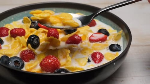 Fruit and Cereal Bowl Being Stirred