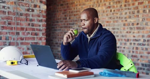 Apple, building and laptop with black man on construction site for planning or problem solving