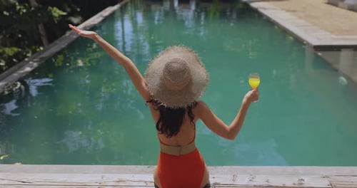 Woman in a Swimsuit and Straw Hat at the Pool During Winter Holidays