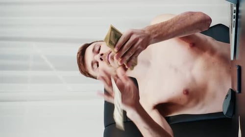 Man scattering dollar banknotes in air at the office