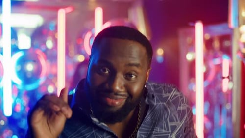 Afro Man Dancing in Neon Nightclub
