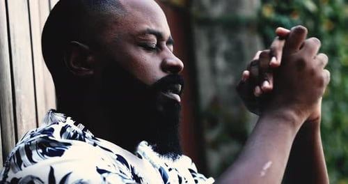 Man in Patterned Shirt Thinking Outdoors in Daylight