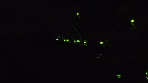 Green LED indicator lights flashing in a dark room, routers processing information