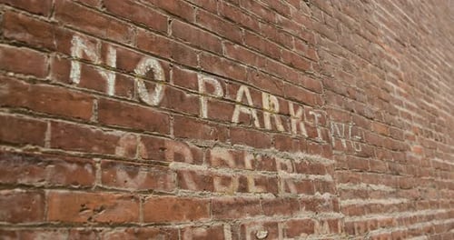 Brick Wall with Painted No Parking Sign - Closeup from Left