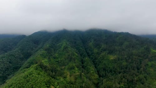 Merapi mount shrouded in clouds, Yogyakarta in Indonesia. Aerial backward