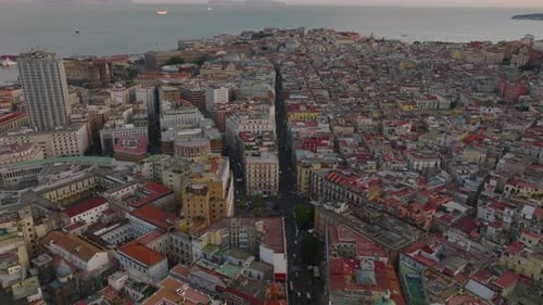 Forwards Fly Above Streets and Various Buildings in Urban Borough Near Sea Coast at Twilight