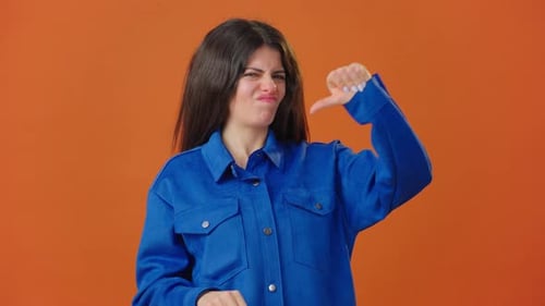 Woman Grimaces and Makes Thumbsdown Showing Displeasure