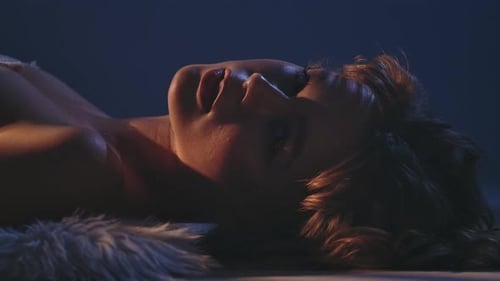 Serene Woman Lying Down in Moody Lighting