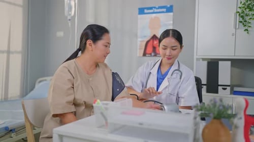 Asian doctor examine patient woman use blood pressure gauge in hospital