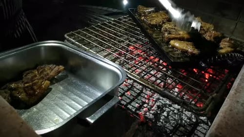 Juicy Meat Cooking over Charcoal at Night