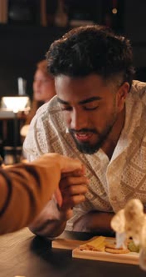 Man, kiss holding hands on date at restaurant for romance, celebration and anniversary dinner