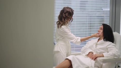 Woman receiving facial treatment from aesthetician in clinic
