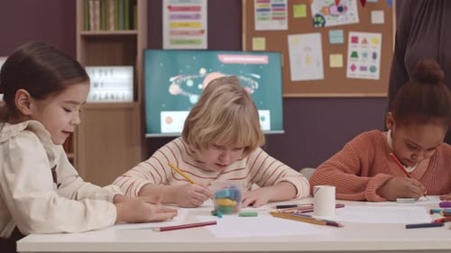 Young Children Draw in Classroom with Teacher