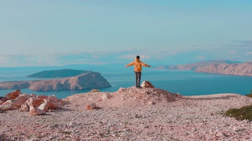 Shot Back Man Tourist Stands Near a Cliff of a Mountain Raises His Arms Feel Freedom Enjoying the