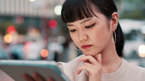 Business, tablet and thinking with Japanese woman outdoor in city for break, email or research