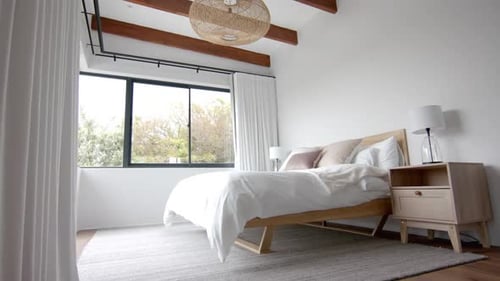 Interior of domestic bedroom with double bed and window overlooking garden, copy space, slow motion