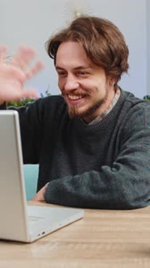 Young Man Video Conferencing on Laptop Indoors