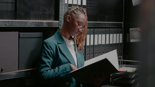 Woman with binder in records room smiling