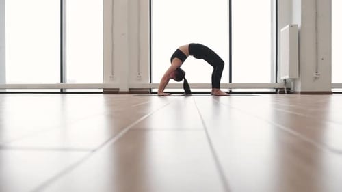 Joli yogi debout dans la pose d'Urdhva Dhanurasana