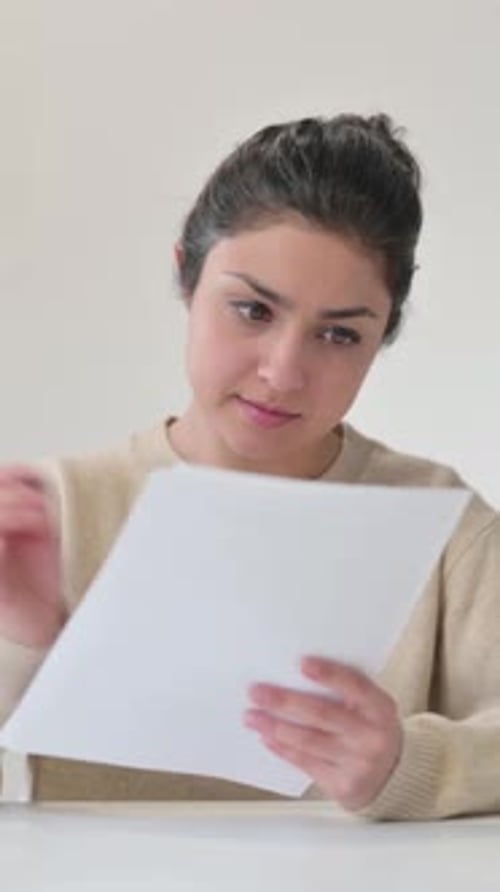Woman Analyzing Documents at Desk in Home Office