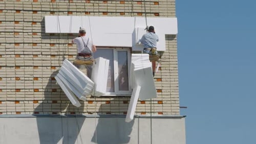 Insulation Work on a Brick Building Exterior