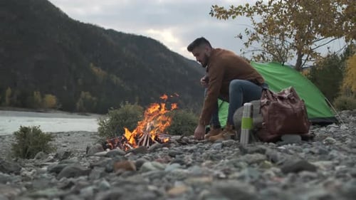 Hiker Tourist Traveler Man with Backpack Mountain Camping Fire Firewood Camp Tent Traveling Hiking