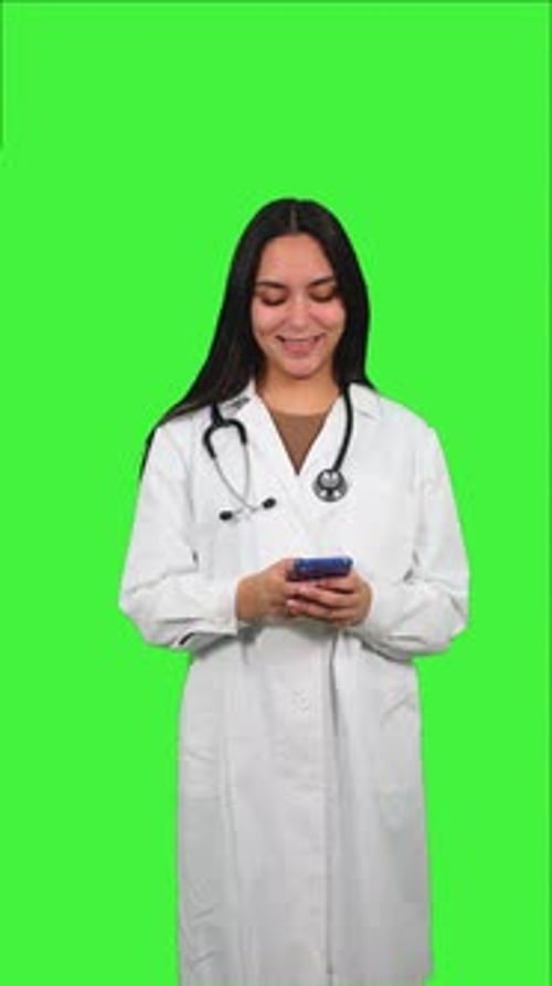 vertical Latin Female Doctor Using Smartphone on Green Screen