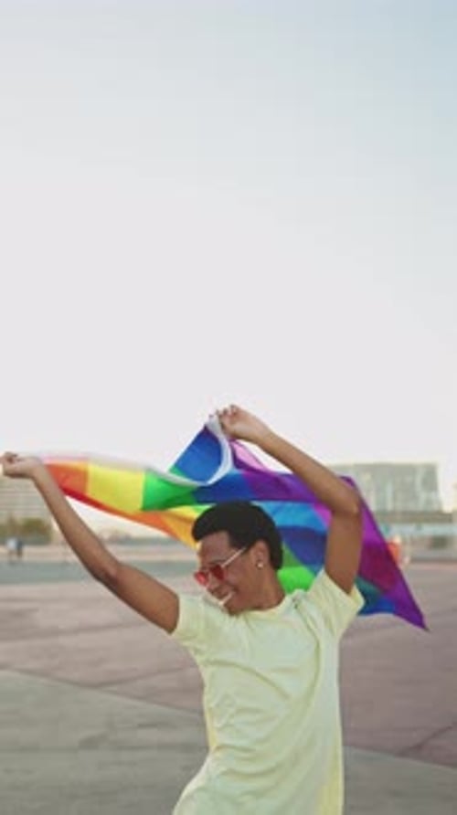 Young Adult Celebrates Pride with Rainbow Flag