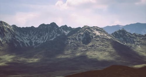 Majestic Snow Capped Mountains Rise Above a Lush Green Valley