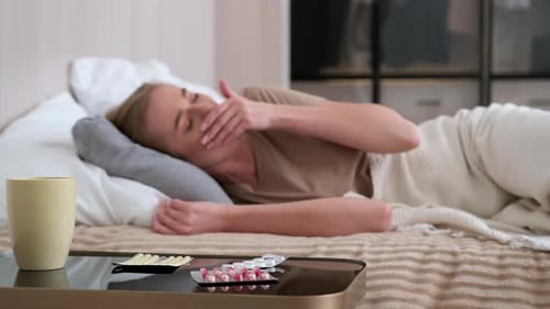 Sick Woman Resting in Bed Taking Medicine