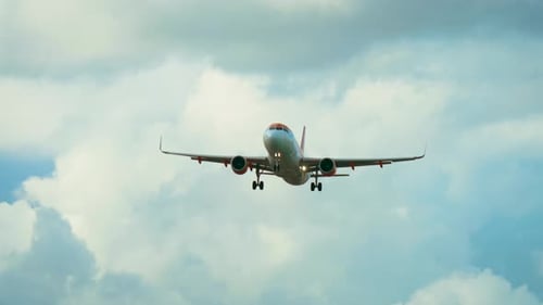 Jet Flying with Landing Gear Extended Against Cloudy Sky Background Airliner Approaching Runway with