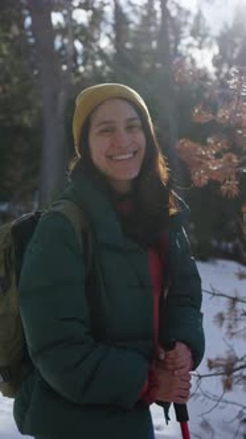 Hiker Smiling and Hiking in Snowy Forest Trail During Winter Day