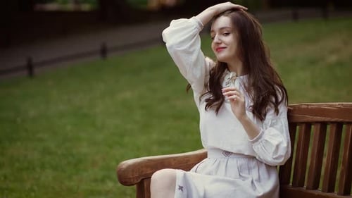 Young Healthy Brunette Woman Smile and Touching Smooth Skin on Face and Fix Her Hair at Public Park