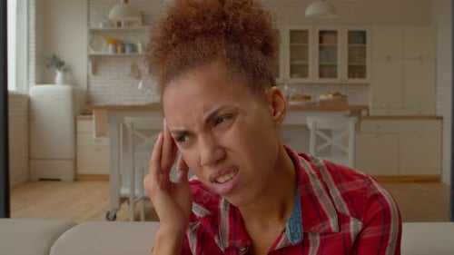 Woman Massaging Temples Due to Headache Pain
