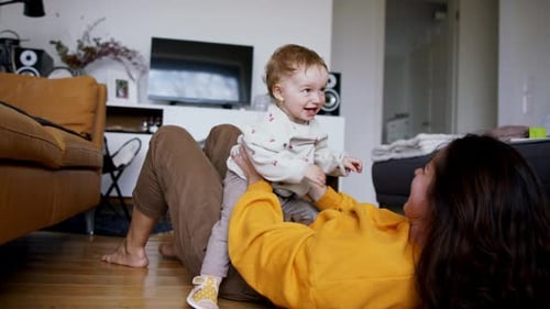 Woman playing with baby on floor at home
