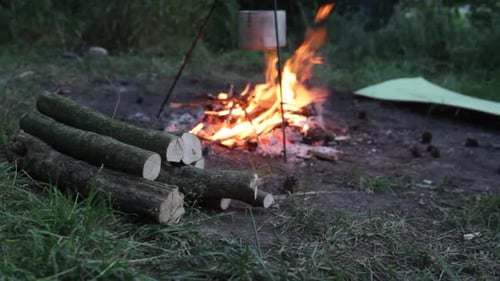 Fogueira queima no meio de um acampamento