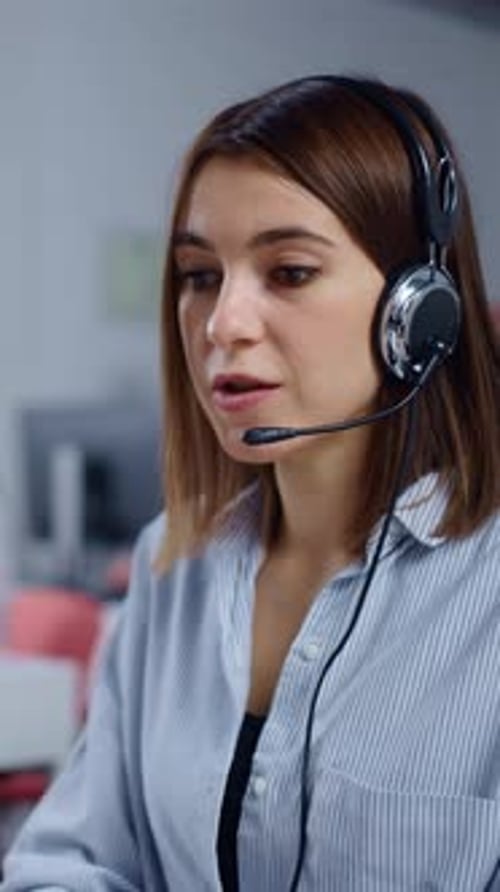 Focused Female Call Center Agent Wearing Headset Working on Computer in Modern Customer Support
