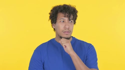 African Man Thinking New Idea on Yellow Background