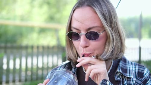 Young Adult Drinks Beverage With Straw Outdoors