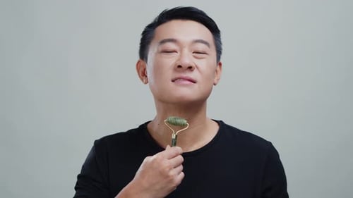 Man using a jade roller on his face