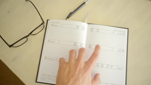 Hands Flip Through Pages Of A Diary Planner