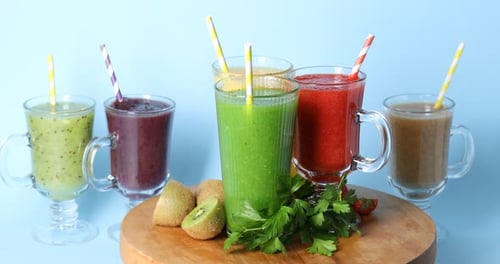 Colorful smoothies with kiwi, parsley, strawberry, and lemons