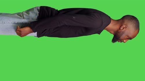 Vertikales Videoprofil eines jungen männlichen Models, das sich stilvoll vor der Kamera posiert