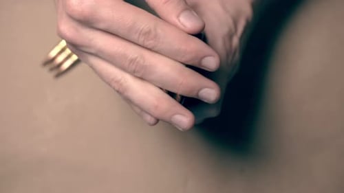 Male hand loading a rifle magazine on a table indoor. Close up top down shot.