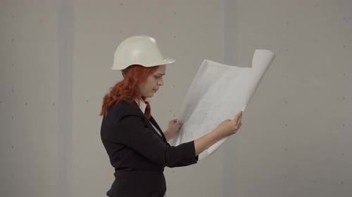 Side View of an Architect Woman Holding a Plan Drawing of a Building in Her Hands A Business Woman