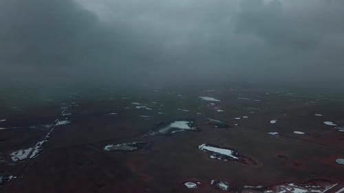 Drone flying through clouds above wasteland