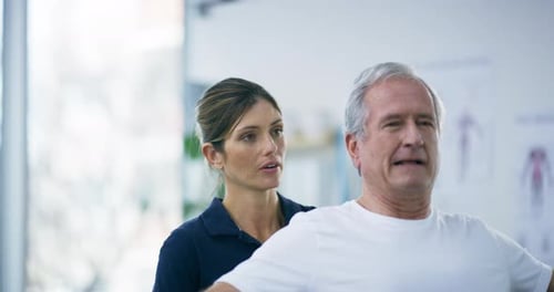 4k video footage of an attractive young female physiotherapist working with a senior male patient