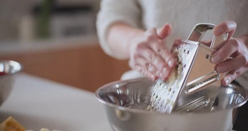 Woman Grating An Apple In Kitchen Baking Pie