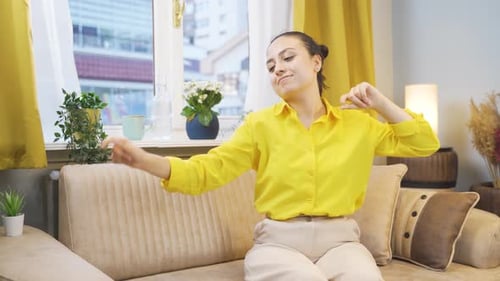 Happy Woman Dancing on Sofa in Living Room