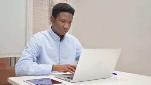 African Businessman Working on Laptop in Office